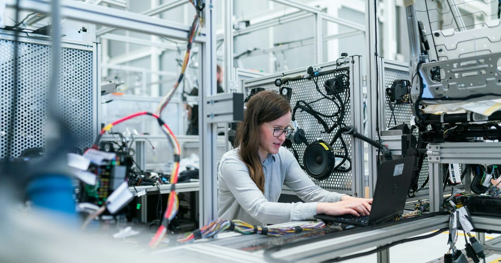 An engineer working at a laptop on an electronics production line