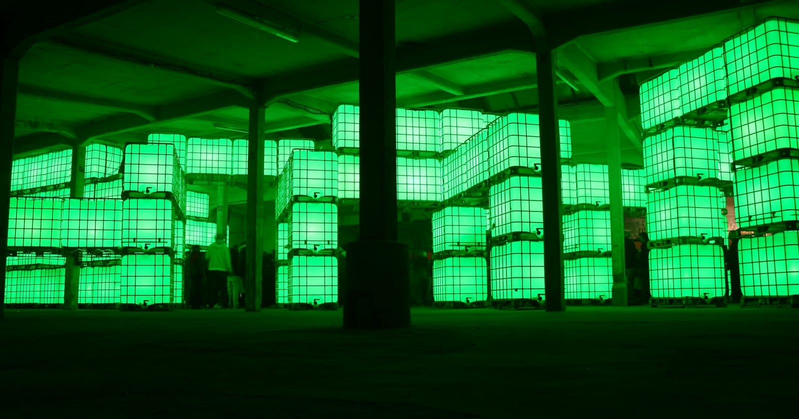 Rows of glowing green LED panels stacked in a dark industrial space
