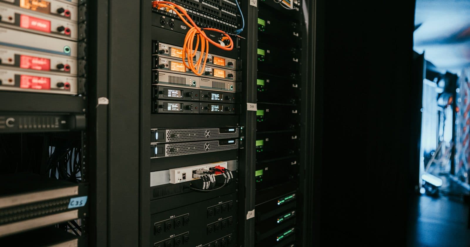 Rack-mounted control hardware in a dimly lit equipment rack